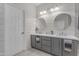 Bright bathroom featuring a double sink vanity, modern mirrors, and white shiplap walls at 13824 W Gelding Dr, Surprise, AZ 85379