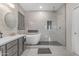 The well-lit bathroom features a soaking tub, glass shower, and double sink vanity at 13824 W Gelding Dr, Surprise, AZ 85379