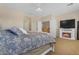 Spacious main bedroom featuring a cozy fireplace, ceiling fan, and carpet flooring at 13824 W Gelding Dr, Surprise, AZ 85379
