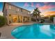 Backyard view of the pool, patio, desert landscaping, and outdoor dining area at 13824 W Gelding Dr, Surprise, AZ 85379