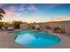 Beautiful backyard with a sparkling pool, rock waterfall, and desert landscaping at 13824 W Gelding Dr, Surprise, AZ 85379