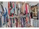 A walk-in closet filled with clothes hanging from the shelves and racks at 13824 W Gelding Dr, Surprise, AZ 85379