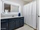 Modern bathroom with navy blue vanity, illuminated mirror, and walk-in shower at 14300 W Bell Rd # 312, Surprise, AZ 85374