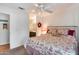 Bedroom with a floral bedspread, a ceiling fan, and an attached bathroom at 14300 W Bell Rd # 312, Surprise, AZ 85374