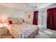 Cozy bedroom with a floral bedspread, red accents, and natural lighting at 14300 W Bell Rd # 312, Surprise, AZ 85374