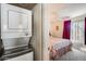 View of a bedroom showcasing the stacked washer and dryer set and purple accents at 14300 W Bell Rd # 312, Surprise, AZ 85374