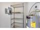 Utility room with water heater, electrical panel, and wire shelving for plenty of storage at 14300 W Bell Rd # 312, Surprise, AZ 85374