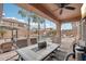 Covered patio with dining table, overlooking a backyard pool with waterfall feature at 14517 W Cortez St, Surprise, AZ 85379