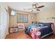 A nice bedroom featuring hard floors, a ceiling fan, and a fun color scheme at 14517 W Cortez St, Surprise, AZ 85379