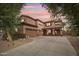 Gorgeous two-story home with a three-car garage, lush landscaping, and a warm, inviting facade at sunset at 14517 W Cortez St, Surprise, AZ 85379