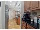 A glimpse of the open kitchen featuring wood cabinets and dark countertops at 14517 W Cortez St, Surprise, AZ 85379