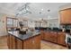 The open kitchen with black countertops, stainless steel appliances, and central island at 14517 W Cortez St, Surprise, AZ 85379