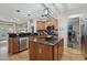 Open kitchen with wood cabinets, black countertops, island and stainless steel appliances at 14517 W Cortez St, Surprise, AZ 85379