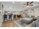 Open-concept living area with a bar, a comfortable sectional sofa, and a dining table with a ceiling fan at 14517 W Cortez St, Surprise, AZ 85379