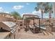 Outdoor kitchen and patio area with a grill, fireplace, and shaded seating at 14517 W Cortez St, Surprise, AZ 85379