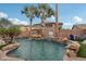 Backyard pool with rock waterfalls, palm trees, and seating area at 14517 W Cortez St, Surprise, AZ 85379