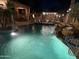 Evening shot of a backyard pool and patio area featuring an outdoor kitchen at 14517 W Cortez St, Surprise, AZ 85379
