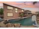Inviting backyard pool with rock features and a basketball hoop under a beautiful sunset at 14517 W Cortez St, Surprise, AZ 85379