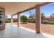 Spacious backyard area with a covered patio, rock landscaping, and mature trees at 15032 N 54Th Pl, Scottsdale, AZ 85254
