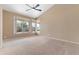 Spacious bedroom featuring neutral carpeting, a modern ceiling fan, and large windows at 15032 N 54Th Pl, Scottsdale, AZ 85254