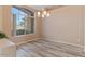 Dining area featuring a modern chandelier, wood-look floors and a large window for natural light at 15032 N 54Th Pl, Scottsdale, AZ 85254