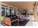 Covered patio with neutral colored floor and sofa, chairs, and grill overlooking the landscaped yard at 15032 N 54Th Pl, Scottsdale, AZ 85254