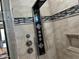 Close-up of an upscale shower system with multiple shower heads, controls, and patterned tiling inside the glass shower stall at 15625 N Jerry St, Surprise, AZ 85378
