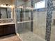 A modern bathroom features a seamless glass shower stall, tiled walls and floors, and decorative mosaic tile accents at 15625 N Jerry St, Surprise, AZ 85378