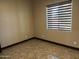 A bright, empty room with tile floors and a window showcasing the neutral color palette at 15625 N Jerry St, Surprise, AZ 85378