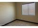 This bedroom features tile floors and a window with modern horizontal blinds at 15625 N Jerry St, Surprise, AZ 85378