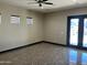 Spacious living room area with a ceiling fan, three windows, and glass patio doors leading to an outdoor pool at 15625 N Jerry St, Surprise, AZ 85378