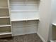 An empty walk-in closet with white shelving, hanging rods, and tile flooring offers plenty of storage space at 15625 N Jerry St, Surprise, AZ 85378
