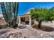 Beautiful backyard featuring desert landscaping, a covered patio, and mature trees at 17317 N Ponca Way, Surprise, AZ 85374