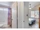 Open bathroom view that leads into bedroom with ceiling fan and window views at 17317 N Ponca Way, Surprise, AZ 85374