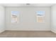 Bedroom with neutral carpeting and two windows providing ample natural light at 17830 W Vogel Ave, Waddell, AZ 85355