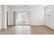 Airy living room featuring sliding glass doors to the backyard, wood-look tile flooring, and white walls at 17830 W Vogel Ave, Waddell, AZ 85355