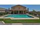 A backyard featuring a refreshing pool, well-manicured artificial turf, and a covered balcony at 1932 S 220Th Dr, Buckeye, AZ 85326