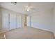 Neutral bedroom featuring carpet, ceiling fan, and a closet with sliding doors at 1932 S 220Th Dr, Buckeye, AZ 85326