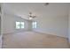 Large bedroom with neutral walls, carpet, ceiling fan, and view of exterior at 1932 S 220Th Dr, Buckeye, AZ 85326