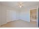 Neutral bedroom with carpet, ceiling fan, and an open doorway to the hallway at 1932 S 220Th Dr, Buckeye, AZ 85326