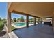 A large covered patio looking out over the refreshing pool and landscaping at 1932 S 220Th Dr, Buckeye, AZ 85326