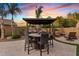 Backyard features a covered dining area with a built-in bar and a cozy seating area with a fire pit at 19748 E Walnut Rd, Queen Creek, AZ 85142