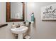 Pedestal sink bathroom features modern decor and a decorative mirror frame at 19748 E Walnut Rd, Queen Creek, AZ 85142