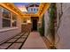 Inviting entryway with stone accents, a paved walkway, landscape and ambient lighting at 19748 E Walnut Rd, Queen Creek, AZ 85142