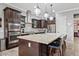 Gourmet kitchen featuring an island with bar seating, built-in appliances, and elegant pendant lighting at 19748 E Walnut Rd, Queen Creek, AZ 85142