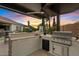 Outdoor kitchen with a grill, counter space, and views of the desert sunset at 19748 E Walnut Rd, Queen Creek, AZ 85142