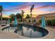 A luxurious pool with a waterfall feature and beautiful desert landscaping create a tranquil outdoor retreat at 19748 E Walnut Rd, Queen Creek, AZ 85142