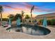 Backyard pool area features stone waterfall, travertine decking, and lush landscaping for a resort-style living experience at 19748 E Walnut Rd, Queen Creek, AZ 85142