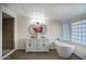 Bright bathroom featuring double sinks, a soaking tub, a glass block window, and a walk-in shower at 19906 N 76Th Ave, Glendale, AZ 85308