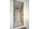 Modern walk-in shower with decorative tiles, a rainfall showerhead, and built-in seating at 19906 N 76Th Ave, Glendale, AZ 85308